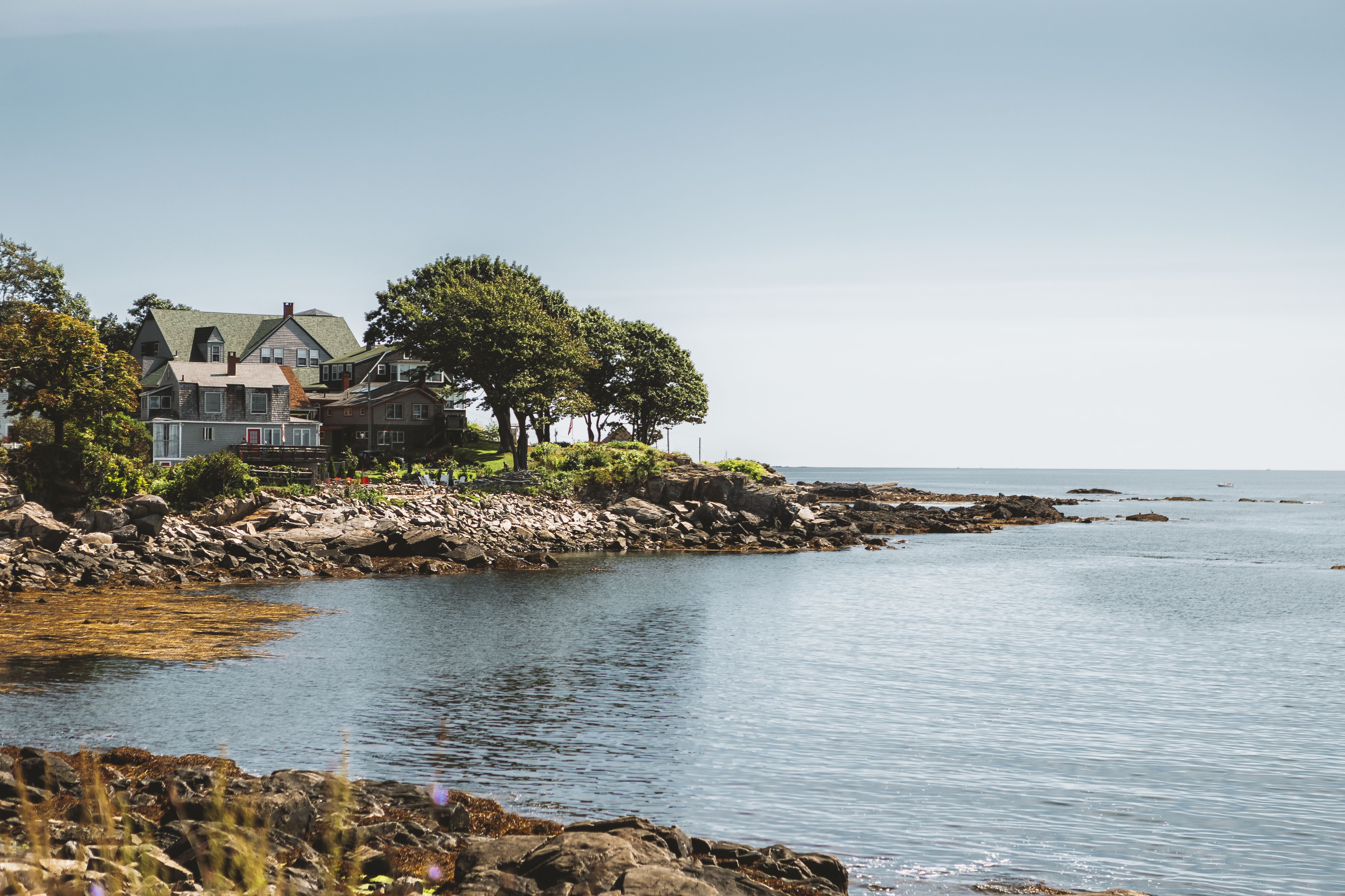 Classic wooden sailboats in a historic New England harbor with lighthouse